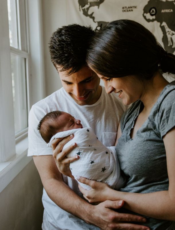 Parents smile at their baby.