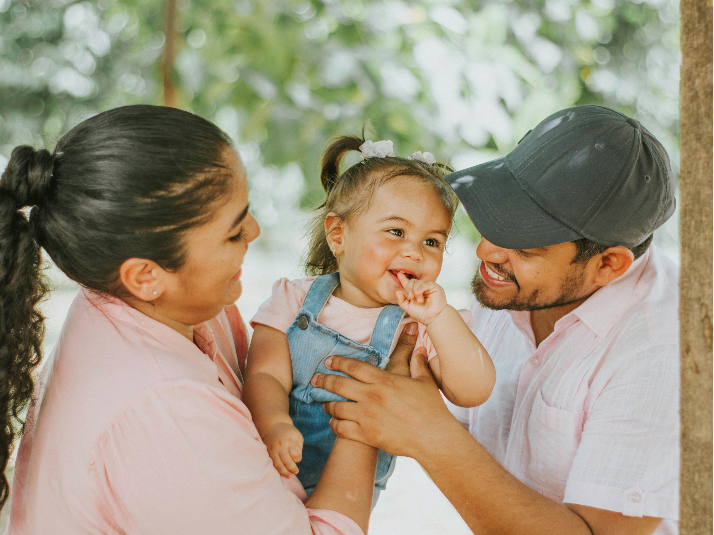 Parents smiling with their toddler.