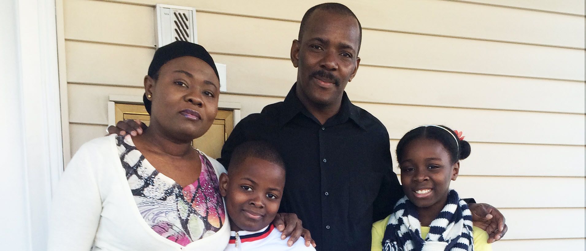 African-American mother and father with their two children ages approximately 8 and 10.