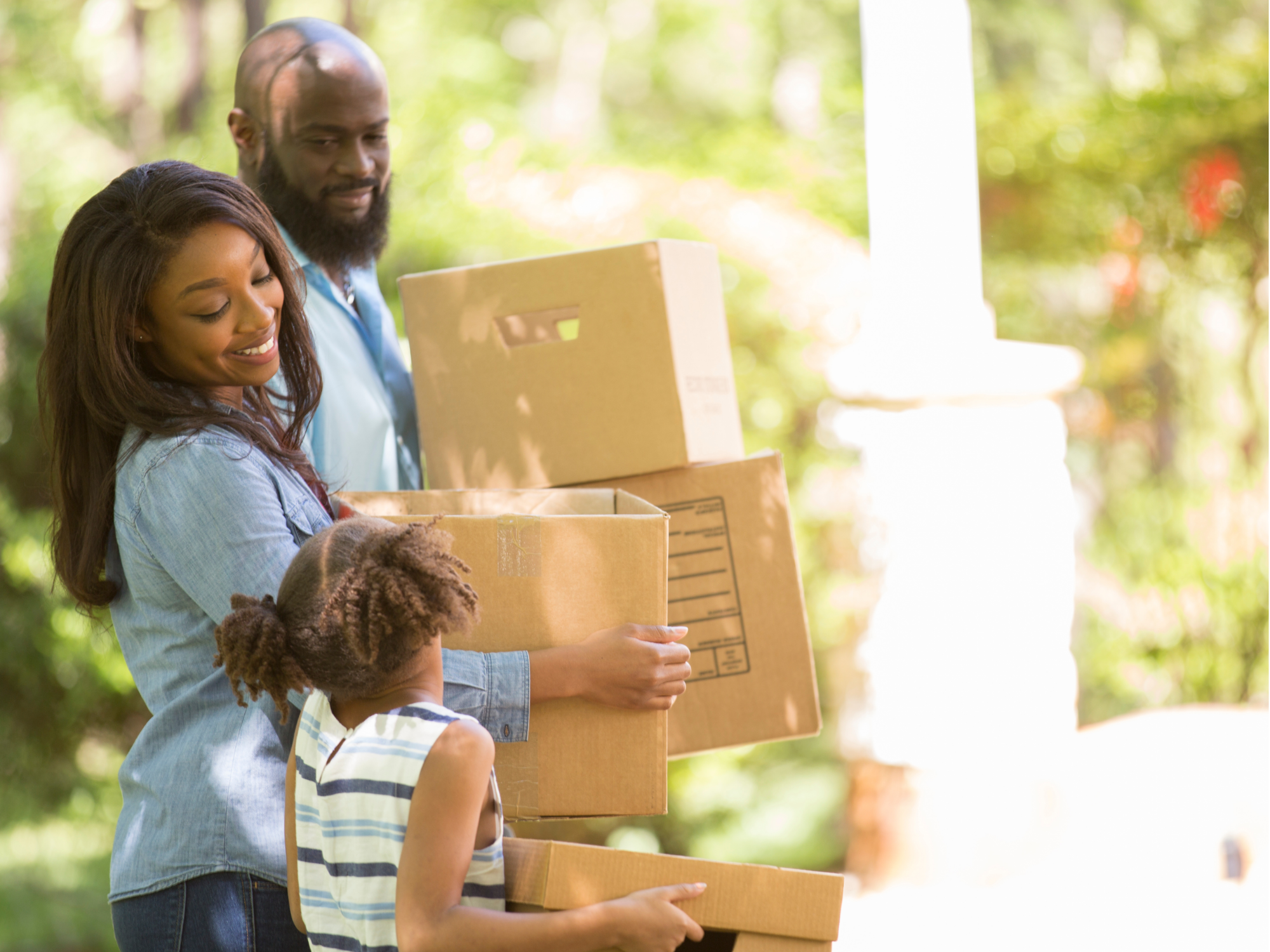 Family smiling with moving boxes.